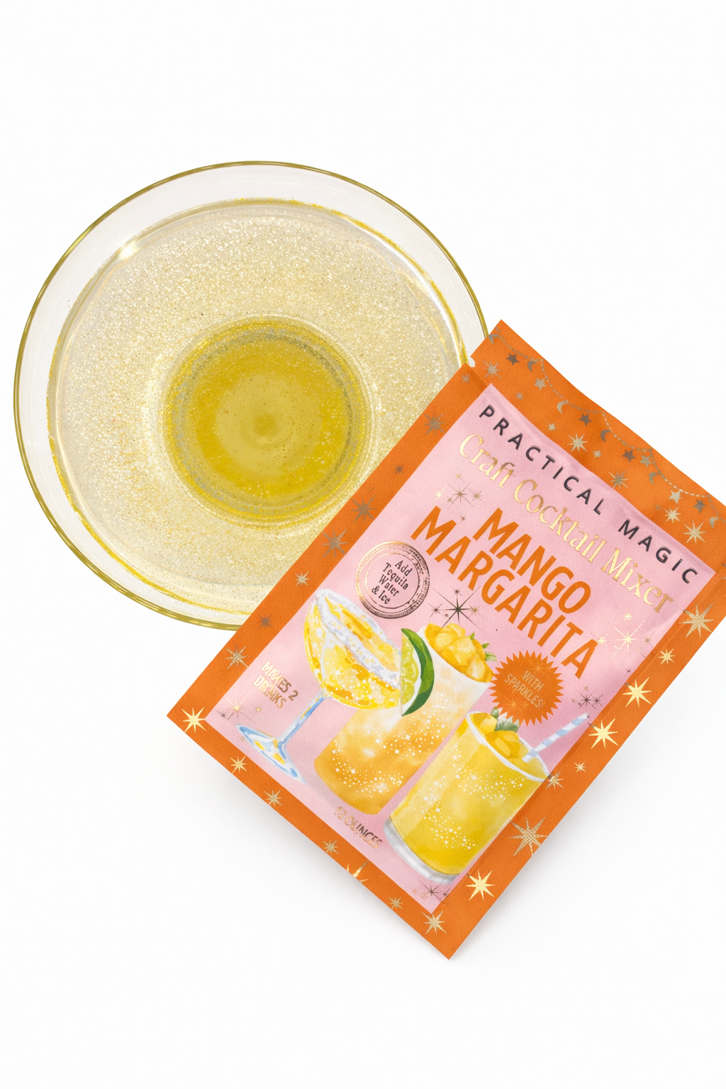 Top view of a sparkling mango margarita in a coupe glass next to mango margarita craft cocktail mixer packet