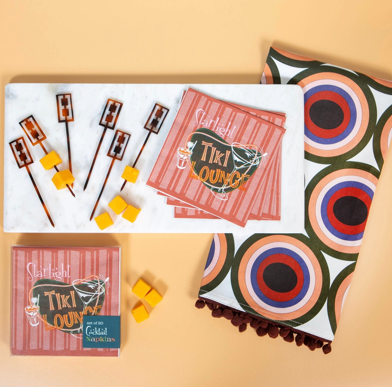 Starlight Tiki Lounge napkins styled with tiki cocktail picks, marble tray, and retro towel