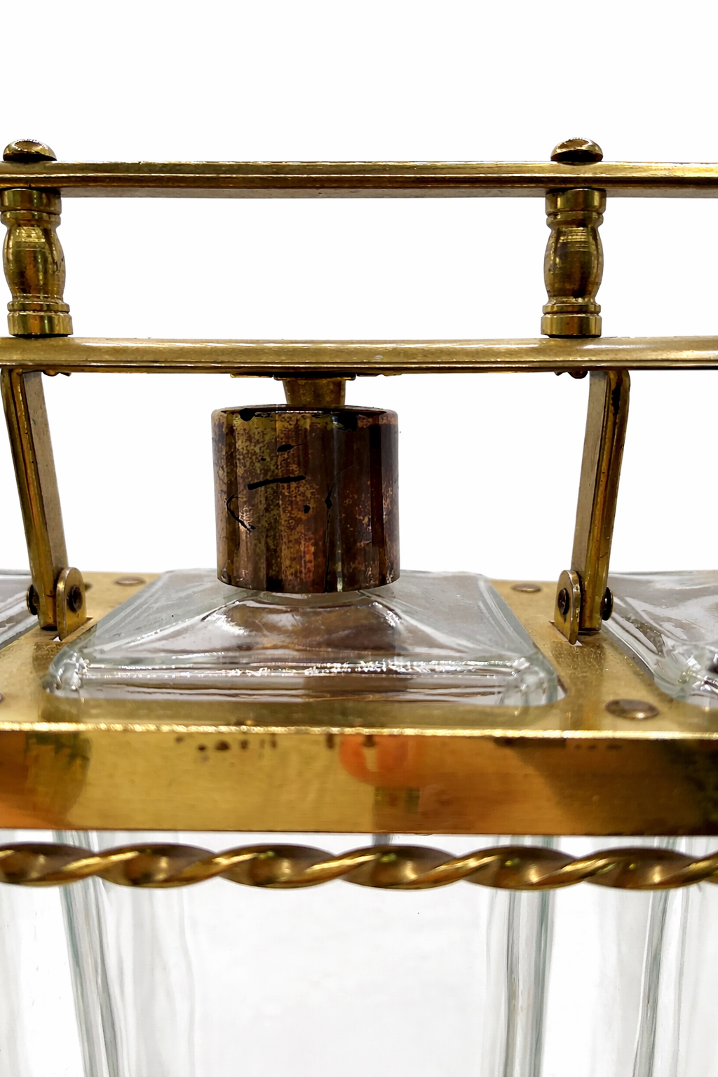 Close up of vintage decanter cap and brass frame showing original patina