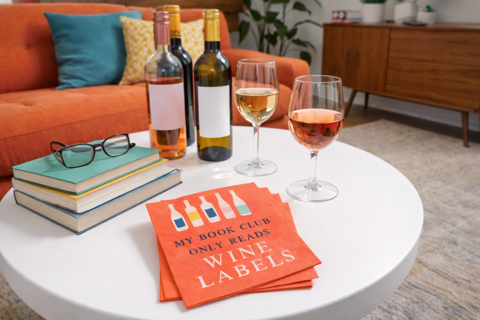 Wine book club cocktail napkins styled on coffee table with wine glasses books and bottles in mid century modern living room