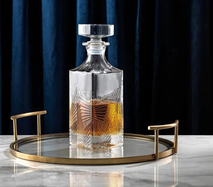 Gatsby art deco decanter displayed on a mirrored bar tray atop a marble surface partially filled with whiskey
