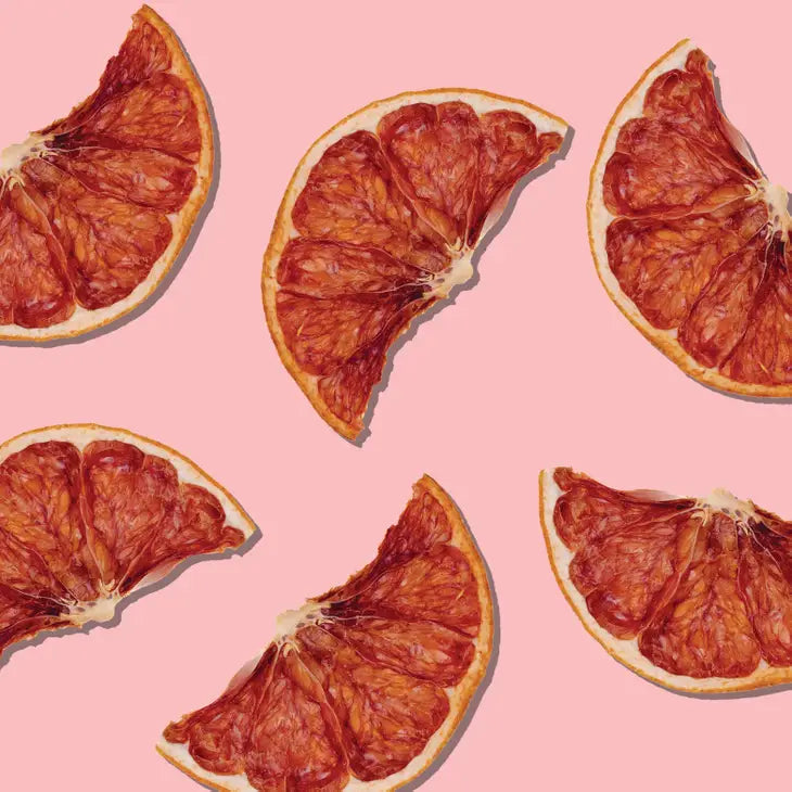 dehydrated grapefruit slices displayed on a bright pink background