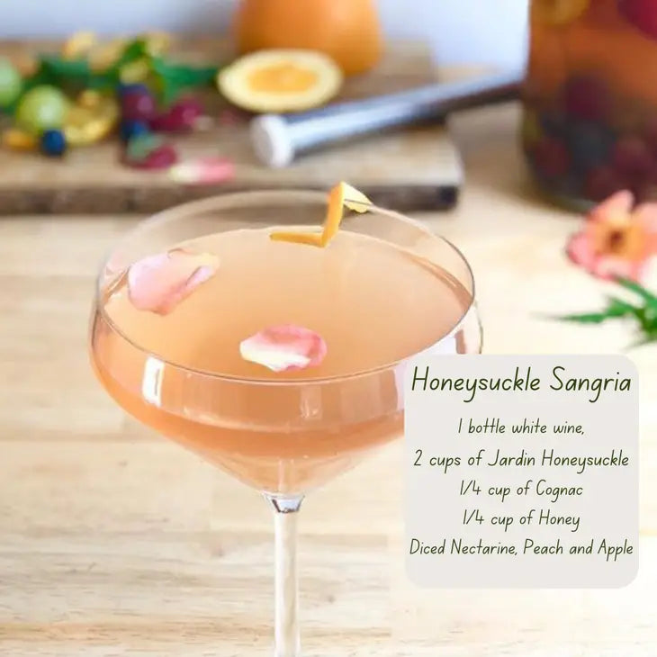 picture of a golden cocktail in a stemmed glass with a recipe for making a honeysuckle sangria using the Jardin honeysuckle mix