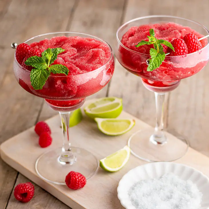 very berry raspberry frozen slushy in margarita glasses garnished with fresh raspberries