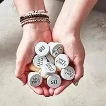 Hands holding a collection of white bottle stoppers 